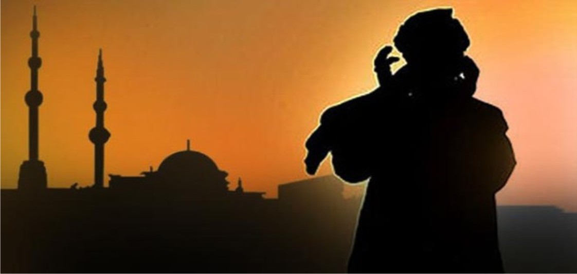 bilal ibn rabah A man stands inside a mosque, seen from behind, raising his hand to his ear while calling the adhan. like bilal inb rabah