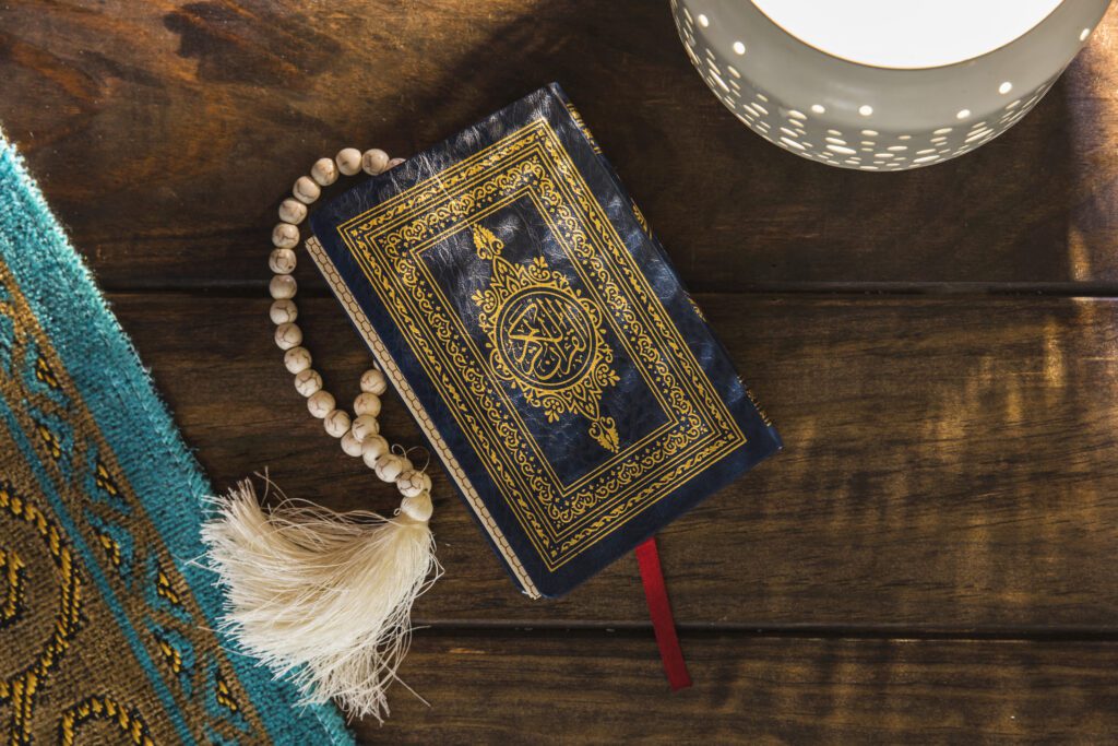 A Quran with a blue and gold cover on a wooden table, symbolizing trustworthiness in Islamic ethics,