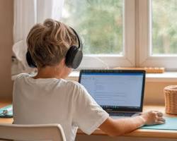 Student attending online tuition on laptop from home